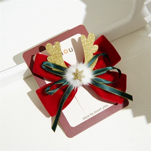 Detail of Christmas bow hair clip with red velvet, green ribbon, and golden antlers