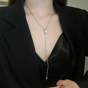 Silver necklace with a white pearl pendant on a model wearing a professional black blazer