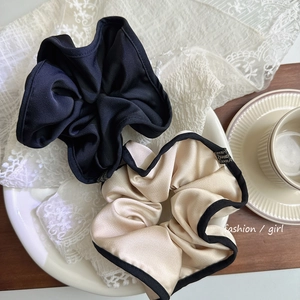 Détail macro de grands chouchous en satin avec étiquettes faites main sur fond de dentelle