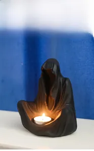 Gothic wizard candle holder detail featuring matte resin hooded figure on table