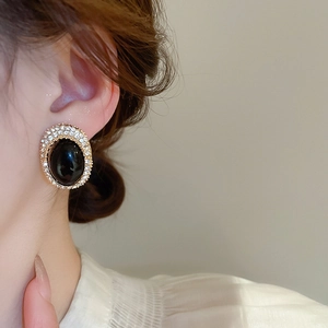 Detail of vintage oval earring with black stone and sparkling zircon halo