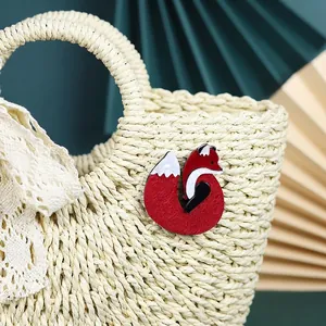 Artistic acrylic red fox brooch pinned on a straw bag with elegant lace decoration