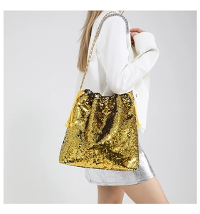 Detailed close-up of a shimmering gold sequin drawstring bucket bag with chain strap