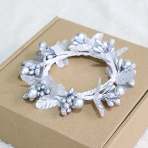 Macro shot of silver Christmas berry wreath napkin ring on a brown cardboard box