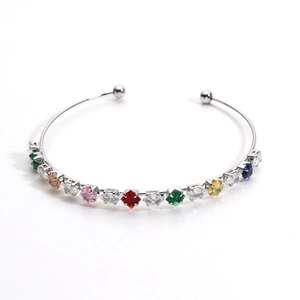 Macro detail of silver bangle with multicolored rainbow zircon stones and open ball ends