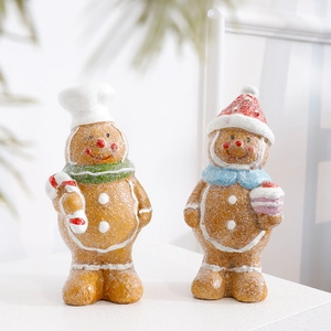 Pair of festive resin gingerbread figurines with chef hat and Christmas accessories