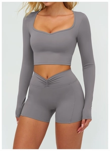 Détail de l'ensemble de yoga gris avec haut à manches longues et short de fitness