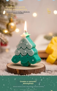 Close-up of tiered green Christmas tree candle with star topper on wooden base