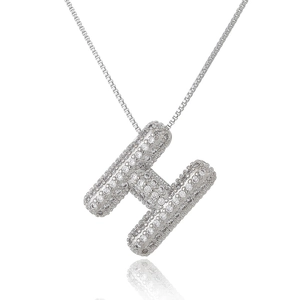 Macro detail of silver H-letter pendant with full pave-set cubic zirconia stones