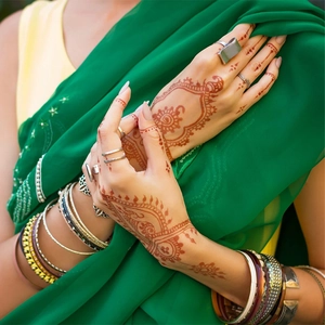 Close-up of red-brown henna lace tattoo stickers on hand with traditional Indian patterns