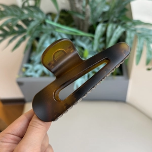 Dettaglio di una grande pinza per capelli in tartaruga scura con design curvo ed elegante