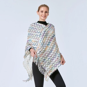 Vue détaillée d'un châle en tricot blanc avec motifs à vagues colorés et franges