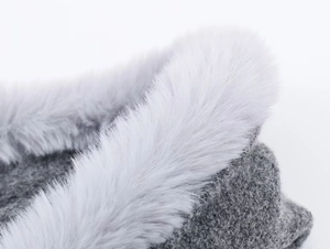 Macro detail of chunky knit texture with plush faux fur collar on a gray hooded cardigan