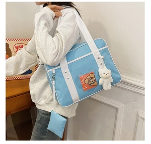 Light blue JK uniform ita bag with heart-shaped window and plush bear charm