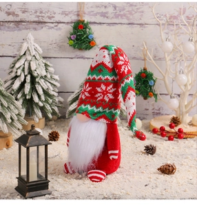 Detail of a Christmas gnome with a knitted hat and white beard in a festive wooden setting