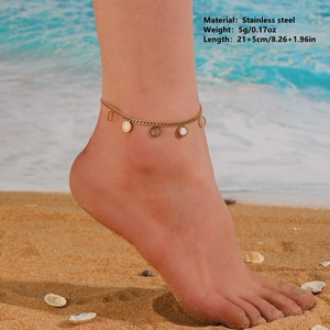 Gold stainless steel anklet with circular white shell charms worn on beach