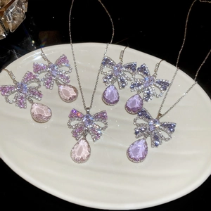Detail of silver butterfly necklace and drop earring set with purple and pink crystals