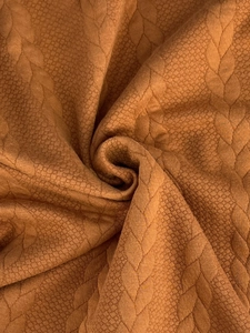 Dettaglio macro del tessuto a maglia jacquard giallo senape con trama morbida e trama