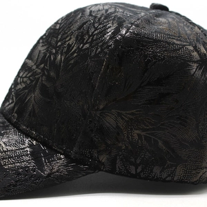 Gros plan d'une casquette noire avec motifs de feuilles en relief et texture mate élégante