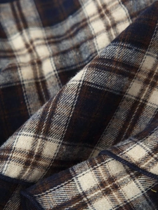 Macro shot of plaid fabric texture in dark blue and beige with soft brushed surface