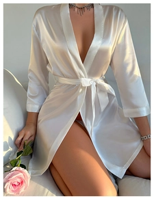 Close-up of elegant white satin robe with a silky texture and a waist tie detail
