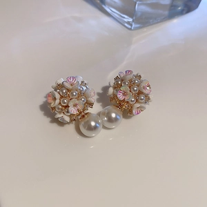 Vue macro de boucles d'oreilles fleurs et perles double face aux pétales brillants