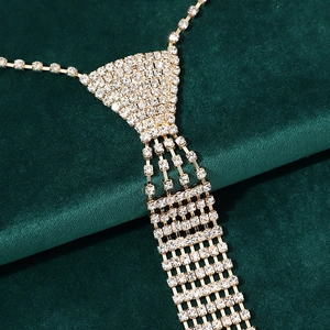 Close-up of sparkling rhinestone necktie necklace on elegant dark green velvet fabric