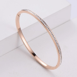 Elegant rose gold oval bangle with cubic zirconia pave setting on white minimalist platform