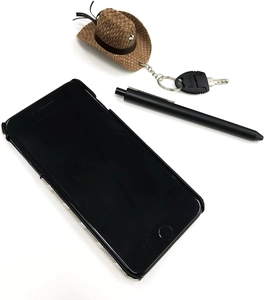 Macro shot of mini brown cowboy hat keychain with silver star stud and black leather band