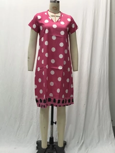 Detail of rose red V-neck polka dot dress showing short sleeves and white dot pattern