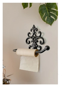 Detailed macro view of vintage cast iron toilet paper holder with fleur-de-lis motif