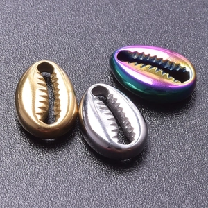 Close-up of shell pendants in gold, silver and rainbow plated stainless steel finish