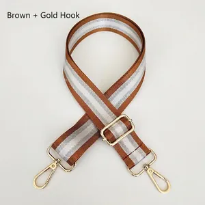 Close-up of adjustable brown and silver striped nylon strap with gold metal hooks