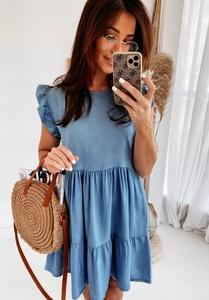 Detail of tiered blue denim dress with ruffled short sleeves and crew neck design