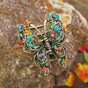 Close-up of vintage butterfly hair claw with colorful enamel and rhinestones on a rock