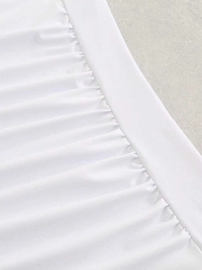Detail of white swimsuit fabric featuring elegant ruching and premium textured finish