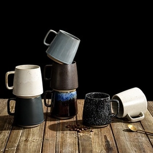 Macro shot of assorted ceramic mug textures and glazes on a dark wooden table