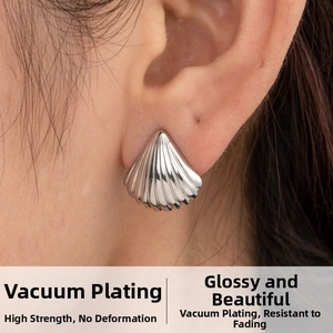 Macro detail of silver shell-shaped titanium steel earring with mirror-like finish