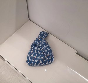 Detail of blue cotton knot bag featuring a white duck pattern and soft linen texture