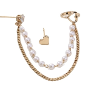Golden heart earring set with pearl fringe chain and ear cuff on white background