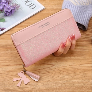 Close-up of pink sequin patchwork long wallet with tassel and golden zipper detail