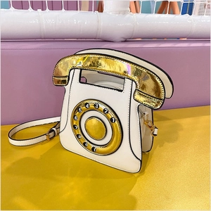 Detail view of retro telephone crossbody bag with metallic gold dial and zipper closure