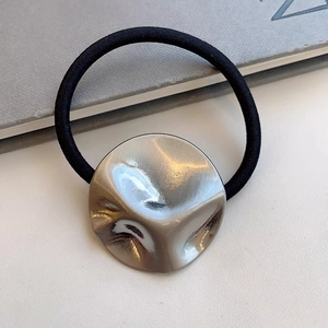Minimalistisch haarelastiekje met een getextureerd zilveren metalen sieraad modern