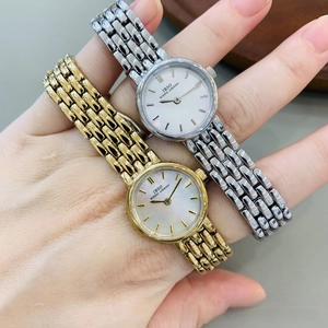 Wrist view of gold and silver quartz watches with pearl dial and metal strap