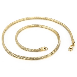 Golden flat snake bone chain necklace in titanium steel with lobster clasp on white background