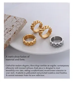 Detail of chunky stainless steel rings with gear-like scalloped edges in gold and silver finish