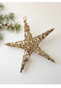 Close-up of golden Christmas star ornament with glitter texture and top hanging loop