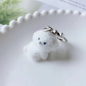 Close-up of white flocked puppy keychain with silver metal lobster clasp and soft texture
