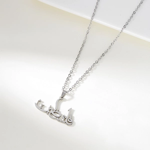 Vue détaillée d'un collier avec pendentif calligraphie arabe argenté au fini poli