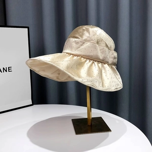 Detail of champagne gold satin sun hat featuring sparkling rhinestones and wide brim